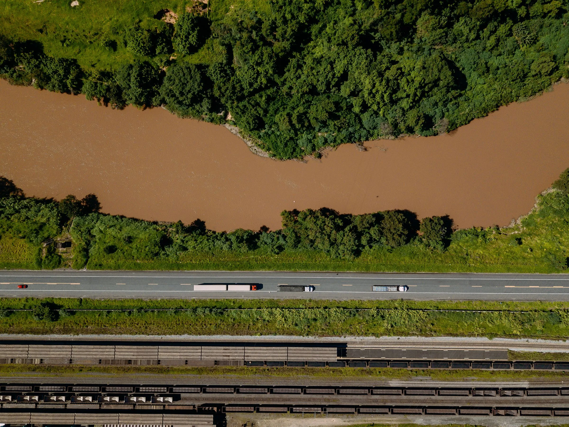 Carretas em rodovia às margens de um rio, em Minas Gerais
